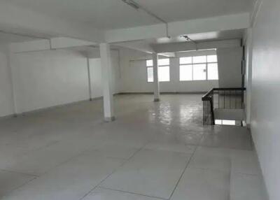 spacious empty room with windows and stair railing