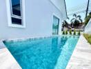 Outdoor swimming pool with clear blue water next to a white building