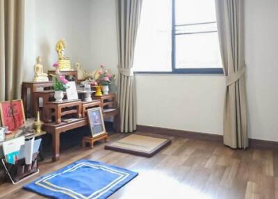 Spacious room with wooden flooring and a Buddhist altar setup