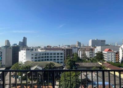 View from a balcony showing a cityscape with multiple buildings and a clear blue sky