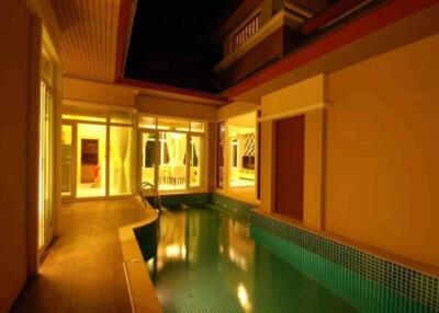 Outdoor pool area at night with illuminated windows