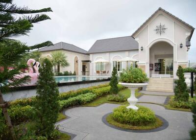 Front view of a residential property with a garden and a pool