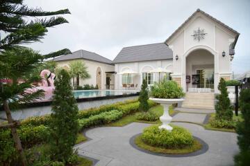 Front view of a residential property with a garden and a pool