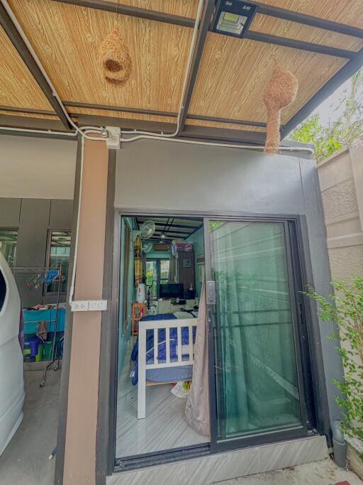 Entrance to a house with sliding glass door and bird nests hanging from the ceiling