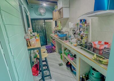 Narrow kitchen with various items and appliances