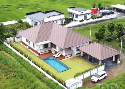 Aerial view of a house with a swimming pool and garden