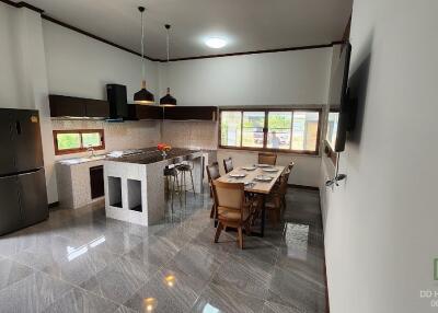 Modern kitchen and dining area with stainless steel appliances and large windows