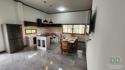 Modern kitchen and dining area with stainless steel appliances and large windows