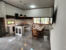 Modern kitchen and dining area with stainless steel appliances and large windows