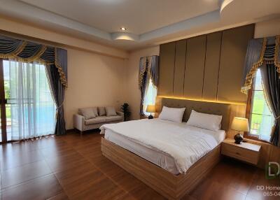 Spacious and elegantly decorated bedroom with a large window and balcony access