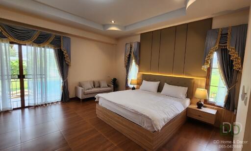 Spacious and elegantly decorated bedroom with a large window and balcony access