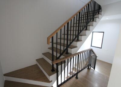 Modern staircase with wooden steps and black metal railing