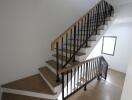 Modern staircase with wooden steps and black metal railing