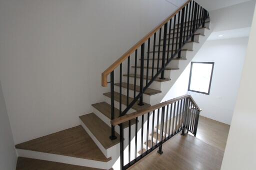 Modern staircase with wooden steps and black metal railing