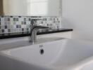 Modern bathroom sink with tiled backsplash