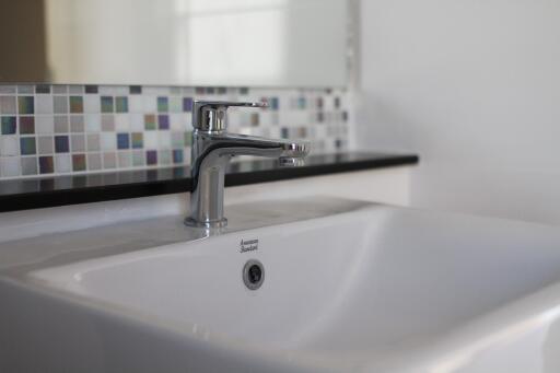 Modern bathroom sink with tiled backsplash