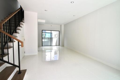 Bright and spacious modern living room with stairs and large window