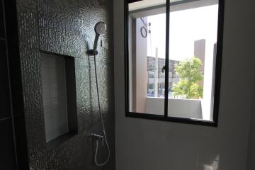 Bathroom with textured wall tiles and window