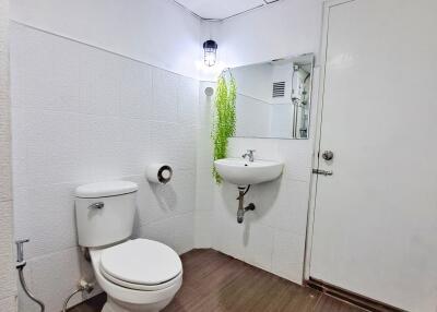 Bathroom with white fixtures and brown flooring