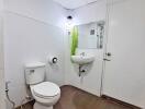 Bathroom with white fixtures and brown flooring