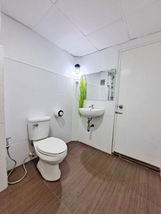 Bathroom with white fixtures and brown flooring