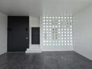 Modern living room with glass block wall and dark tiled floor