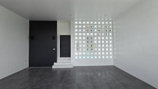 Modern living room with glass block wall and dark tiled floor