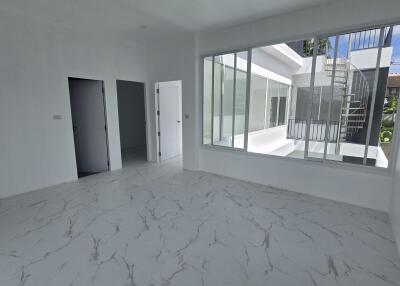 Bright living space with large windows and marble floor tiles