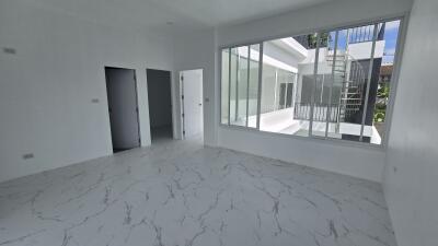 Bright living space with large windows and marble floor tiles