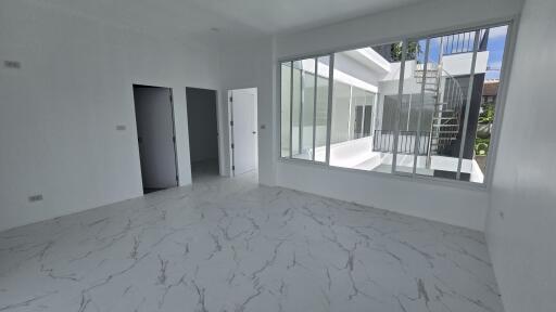 Bright living space with large windows and marble floor tiles