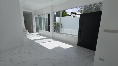 Bright and airy living area with large windows and sleek flooring