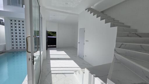 Modern living area with pool view and stairs