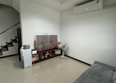 Living room with staircase and air conditioner