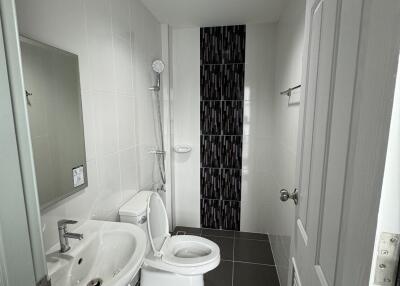 Modern bathroom with white fixtures and a black-tiled shower area