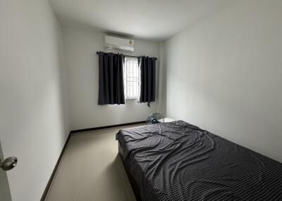 Simple bedroom with bed, window, and air conditioning