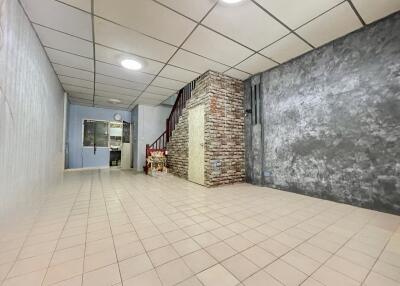 Spacious living area with tiled floor and staircase