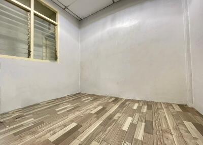 Empty room with wooden flooring and a window