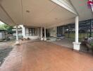 Spacious covered outdoor space with tiled flooring and built-in seating