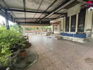 Covered outdoor patio with plants and bench seating