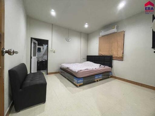 Spacious bedroom with bed, air conditioner, and sofa