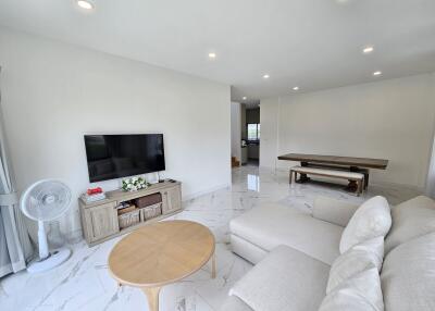 Modern living room with marble flooring and neutral-toned furniture