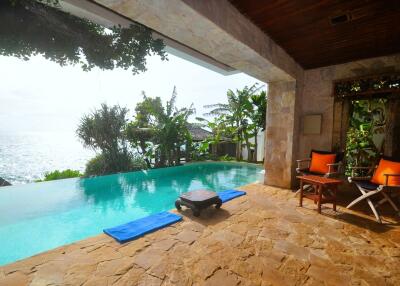 Tropical outdoor lounging space with infinity pool and ocean view