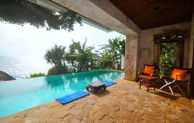 Tropical outdoor lounging space with infinity pool and ocean view