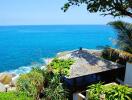 A stunning view of the ocean with a beachfront property surrounded by lush greenery