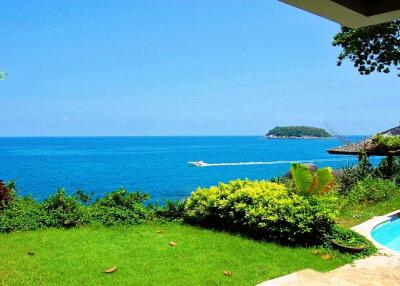 View of a seaside property with garden and pool