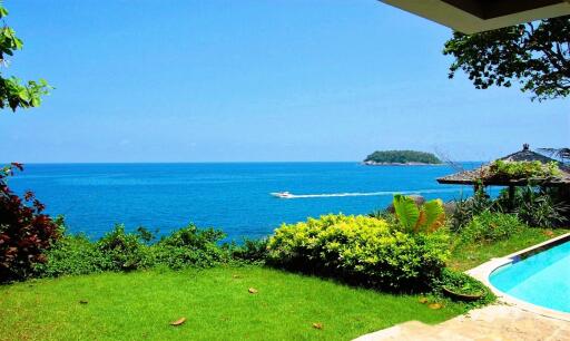 View of a seaside property with garden and pool