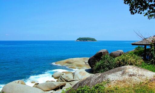 Seaside view with rocks and small island in the background