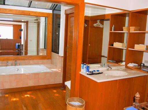 Spacious bathroom with wooden accents and large mirror