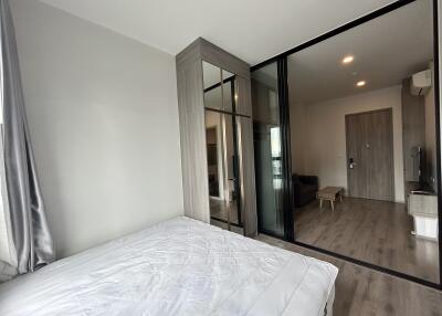 Modern bedroom with large glass wardrobe and view into an adjacent living area