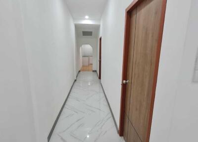 Hallway with wooden door and marble floor